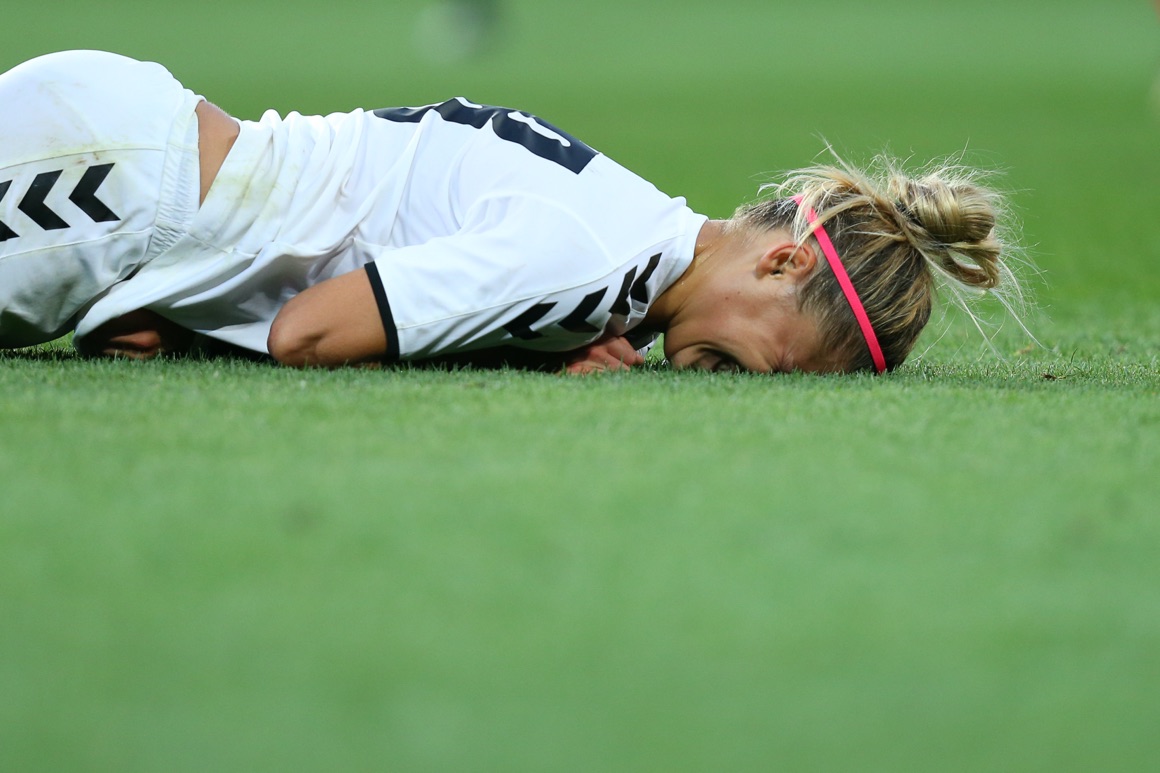 Female player falling down on the pitch with injury after hard collision