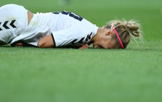 Female player falling down on the pitch with injury after hard collision